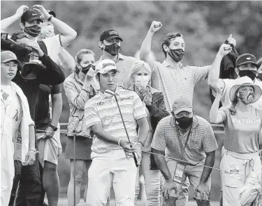  ?? Curtis Compton / Associated Press ?? Augusta National spectators react as Hideki Matsuyama chips it close to the cup from the gallery to save par en route to a 7-under 65 finish. Matsuyama is currently at 11 under and leads by four shots.