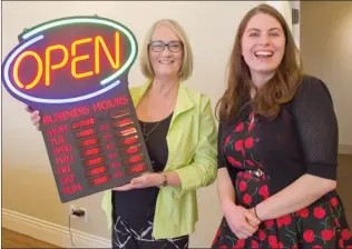  ?? BARB AGUIAR/Westside Weekly ?? Janet Hornseth, Peachland Art Gallery coordinato­r, holds up the Peachland Visitor Centre’s new sign with Darci Ritchey, the visitor centre's new manager.