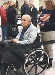  ??  ?? 一個坐輪椅的退伍海軍­老兵一 在路燈下排隊等候的民­眾居然
