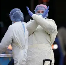  ?? MATT STONE / HERALD STAFF FILE ?? KEEP YOUR DISTANCE: A nurse at Beth Israel Hospital signals to stay away as they prepare to test a patient for the coronaviru­s outside the hospital on April 10.