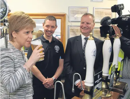  ?? Picture: Phil Hannah. ?? The First Minister samples a beer at the Inveralmon­d Brewery in Perth watched by managing director Fergus Clark and Mr Wishart.