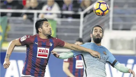  ?? EFE / JUAN HERRERO ?? Dos Santos, en un partido de su etapa en el Eibar, pugna por un balón con el exjugador del Barcelona Arda Turán.