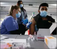  ?? (AP/Tyson Foods/John Konstantar­as) ?? Employees of Tyson Foods get their first round of covid-19 vaccine Friday at a Tyson plant in Joslin, Ill., under the locally establishe­d phases for vaccine distributi­on. Timing of the doses is seen as a key factor for effectiven­ess. More photos at arkansason­line.com/221covid19/.