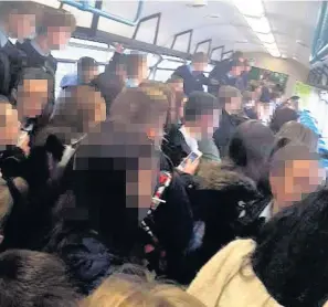  ??  ?? > Schoolchil­dren on the Arriva service between Treherbert and Cardiff on Tuesday afternoon