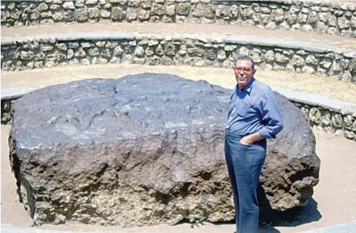  ?? BOB JONES ?? Dick Bideaux stands by the multi-ton Hobe nickel-iron meteorite in Africa.