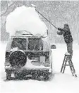  ?? DAVID DUPREY AP ?? A resident of Clarence, N.Y., a suburb of Buffalo, clears his van on Dec. 28, 2001.