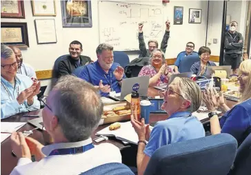  ?? PHOTOGRAPH: NASA/JPL-CALTECH/COVER IMAGES ?? The flight team celebrate at Nasa’s Jet Propulsion Laboratory after finally hearing from Voyager 1 (artist’s impression, far left)