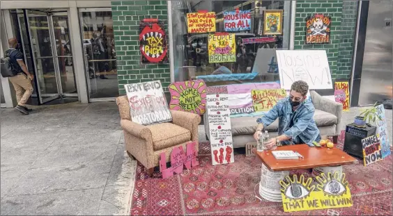  ?? Mary Altaffer / Associated Press ?? Housing advocates set up a living room on Monday during a demonstrat­ion outside the building that contains Gov. Andrew Cuomo's office in New York. The activists were demanding safe and stable housing for all New Yorkers and the extension of the eviction moratorium.