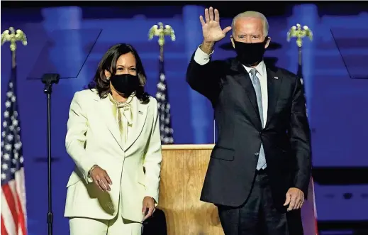  ?? ANDREW HARNIK/AP ?? President-elect Joe Biden takes the stage with Vice President-elect Kamala Harris on Saturday in Wilmington, Del. After defeating President Donald Trump and Vice President Mike Pence, the two called on a divided nation to seek common ground.