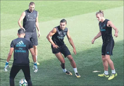  ??  ?? Casemiro, en un rondo con Benzema y Bale en la sesión de ayer, podría jugar en el centro de la defensa junto a Nacho Fernández