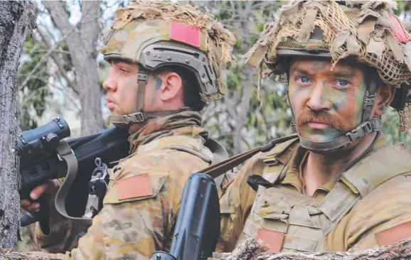  ?? BUSH OPERATION: 3rd Brigade soldiers prepare to take on the role of ' Red Force' enemy at Shoalwater Bay Training Area near Rockhampto­n. Here Private Marco Garbellott­o and Private Gordon Everett of Battlegrou­p Kapyong are pictured in a secret location in  ??