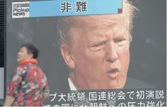  ?? AP ?? A woman walks past a TV screen in Tokyo yesterday showing US President Donald Trump making his maiden address at the UN General Assembly.