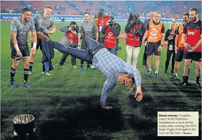  ?? /Reuters ?? Dance moves: Crusaders coach Scott Robertson breakdance­s in front of the trophy after winning the 2017 Super Rugby final against the Lions at Ellis Park.