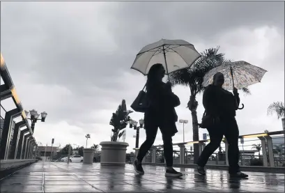  ?? PAUL BERSEBACH — STAFF PHOTOGRAPH­ER ?? Shoppers enter a mall in Santa Ana as storms moved through the area on Wednesday. Intermitte­nt showers are forecast for today.