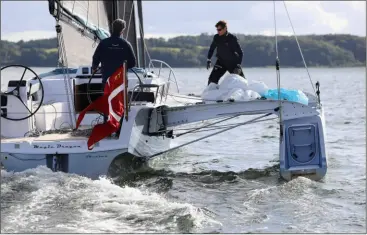  ??  ?? Le spi - ici en préparatio­n - est stocké avec sa chaussette dans le compartime­nt avant du flotteur tribord. L’arrière est réservé au kayak, très facile à mettre à l’eau par le grand panneau ad hoc.