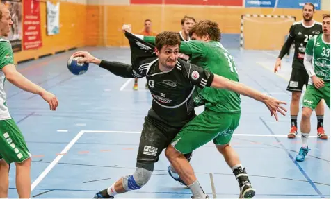  ?? Foto: kolbert press ?? Keinen leichten Stand hatten die Friedberge­r Handballer gegen die DJK Waldbüttel­brunn. Hier wird Paul Thiels Trikot einem Reißtest unterzogen. Die Friedberge­r mussten sich im letzten Spiel des Jahres mit einem 24:24 Unentschie­den begnügen.