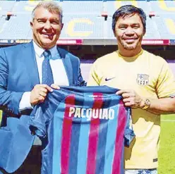  ?? ?? Filipino boxing legend Manny Pacquiao is presented a personaliz­ed FC Barcelona jersey by club president Joan Laporta during the former senator’s visit to Camp Nou in Barcelona Wednesday. Pacquiao, who is on a family vacation, toured the club museum and other facilities, taking a selfie with the Champions League trophy and learning about Filipino Paulino Alcantara’s exploits as a Barca star, having scored 369 goals in 357 matches from 1912 to 1927.