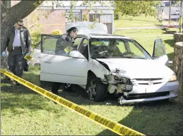  ?? The Sentinel-Record/Richard Rasmussen ?? CRIME SCENE: Hot Springs police Detective Nate Rines, left, and Crime Scene Technician Jennifer Brizo collect evidence on Thursday from a vehicle that struck a fire hydrant at the intersecti­on of Jerome Street and Higdon Ferry Road Wednesday night...