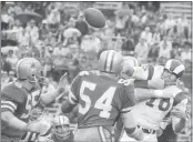  ?? THE ASSOCIATED PRESS, FILE ?? Rams quarterbac­k Roman Gabriel, right, is hit by a host of Cowboys as the ball heads for the sidelines during a 1970 NFL playoff game in Miami, Fla. Gabriel, who was the 1969 MVP with the Rams, died Saturday. He was 83.