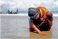  ?? Reuters ?? An exhausted Rohingya refugee woman touches the shore after crossing the Bangladesh-Myanmar border by boat through the Bay of Bengal, in Shah Porir Dwip, Bangladesh. —