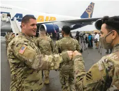  ?? STEPHEN B. MORTON/AP ?? Soldiers and command staffers bump fists at Hunter Army Airfield in Savannah, Georgia.