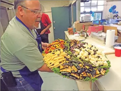  ??  ?? John Nicoletti, a Marysville Kiwanis Club member, helps prepare food for the hundreds of guests yet to arrive at the Yuba-Sutter Fairground­s for the 30th annual Italian Night on Saturday.