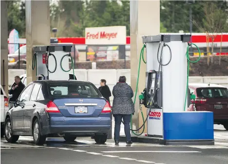  ?? ARLEN REDEKOP/PNG ?? Canadian visitors fill up on gas in Bellingham, Wash. B.C. drivers looking for cheap gas make up a lot of cross-border traffic.