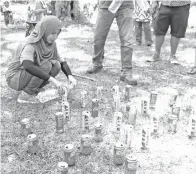  ??  ?? WARTAWAN Borneo Today Suraidah Roslan sibuk mengisi air ke dalam tin bagi acara sukaneka.