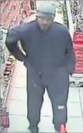  ??  ?? n CCTV: The knife-wielding robber in Ruislip