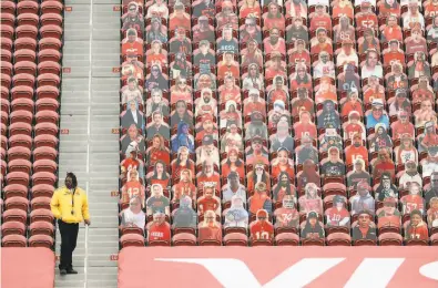  ?? Scott Strazzante / The Chronicle ?? An usher at Levi’s Stadium stands next to an endzone section of fan cardboard cutouts. The cardboard fans were a cute idea at first, but it’s starting to get creepy.