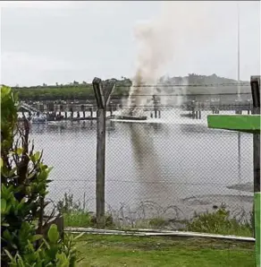  ??  ?? Smoke on the water: The Royal Malaysian Navy P38 intercepti­on boat burning at the dock in Semporna.