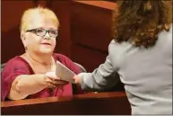  ?? Amy Beth Bennett / Associated Press ?? Lynn Rodriguez, Cruz’s third and fourth grade special education teacher, hands documents back to Assistant Public Defender Tamara Curtis as she testifies.