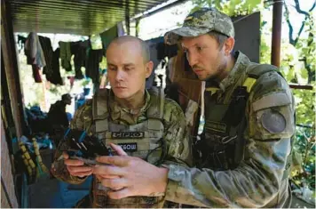  ?? EVGENIY MALOLETKA/AP ?? Ukrainian servicemen correct artillery fire by drone July 2 at the front line near Kharkiv, Ukraine.