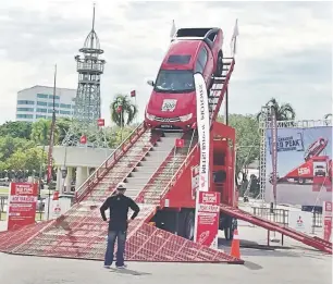  ??  ?? JOM SERTAI: Pengurus Jualan Jimisar Autotrade Sdn Bhd, Sim Hock Sing dan wakil jualan Mitsubishi merakamkan kenangan di Mitsubishi Red Peak Challenge.