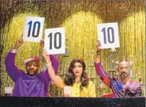  ??  ?? A PANEL of ballroom “judges” hold up their perfect scores between takes in the filming of the ball scene on “Pose” set.