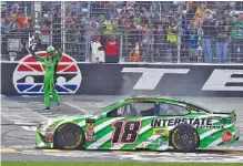  ?? THE ASSOCIATED PRESS ?? Fans watch Kyle Busch wave the checkered flag in celebratio­n Sunday at Texas Motor Speedway in Fort Worth. Busch, who led the season points standings even before Sunday, got his first Cup Series win of the year and ended a streak of 10 races without a...