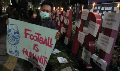  ?? ?? A man holds a poster during a candle light vigil for the victims of the tragedy in Indonesia. Photograph: Dita Alangkara/AP