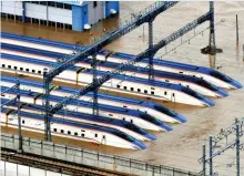  ??  ?? Going nowhere: Bullet trains stranded in water