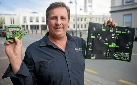  ?? BEJON HASWELL/STUFF ?? Below, racing driver Murray Beeby with the board game designed on the Levels circuit and which the South Canterbury Car Club hopes will generate interest in motorsport.