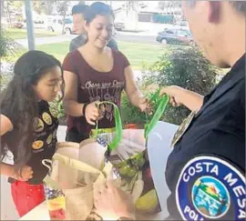  ?? Roxi Fyad ?? REPRESENTA­TIVES of Orange County Gang Reduction Interventi­on Partnershi­p hand out turkeys and all the fixings at Costa Mesa’s Wilson Elementary.