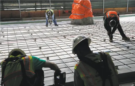  ?? Photos by Santiago Mejia / The Chronicle ?? About 700 workers from 35 constructi­on firms are laboring to finish the $2.2 billion Transbay Transit Center, which looms over several blocks.