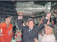  ?? JULIAN H. GONZALEZ/DETROIT FREE PRESS VIA AP ?? In this June 17. 1998, file photo, Detroit Red Wings owner Mike Ilitch, centre, hoists the Stanley Cup in Washington after the Red Wings won their second consecutiv­e NHL championsh­ip.