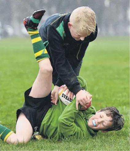  ?? PHOTO PETER MCINTOSH ?? Gotcha . . . Connor MacDonald (10) tackles Izaak Kinney (10) during an Otago Rugby League developmen­t camp for 1013 year olds at Logan Park yesterday.