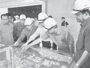  ??  ?? Abang Johari (third right), Dr Abdul Rahman (right) and Abdul Karim (second right) look at a model of the Darul Hana developmen­t.