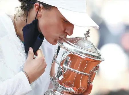  ?? REUTERS ?? Poland’s Iga Swiatek kisses the trophy after beating American Sofia Kenin 6- 4, 6- 1 to win the French Open title on Saturday.