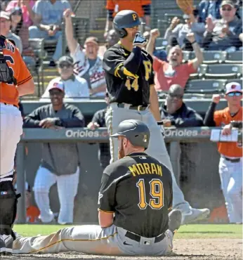  ?? Matt Freed/Post-Gazette photos ?? PIrates runner Colin Moran is tagged out at home by Baltimore catcher Bryan Holaday Thursday, above left, then sits dejectedly on the plate. The Pirates lost to the Orioles, 13-0, in Sarasota, Fla., to fall to 0-6-1 this spring.