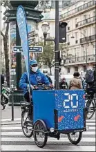  ??  ?? Distributi­on de 20 Minutes dans Paris en triporteur, en octobre 2020.