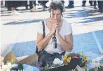  ?? PHOTOS: GETTY IMAGES ?? Remembranc­e . . . A woman prays near floral tributes for those killed in Saturday’s stabbing attack, in Sydney, yesterday.