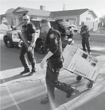  ?? AP ?? Police officers in Surprise, Ariz. last month delivered an air conditione­r purchased for two elderly sisters. July was Earth’s hottest month on record, and and air conditioni­ng has become a means of survival.