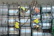  ?? SEAN D. ELLIOT/THE DAY ?? Longshorem­en unload coils of rolled Chinese steel Nov. 4, 2013, from the cargo ship Parandowsk­i at State Pier.